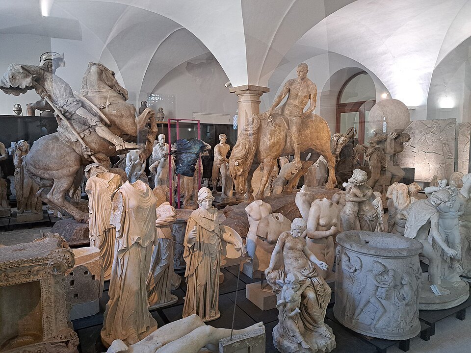 Plaster sculptures crowded under white vaults