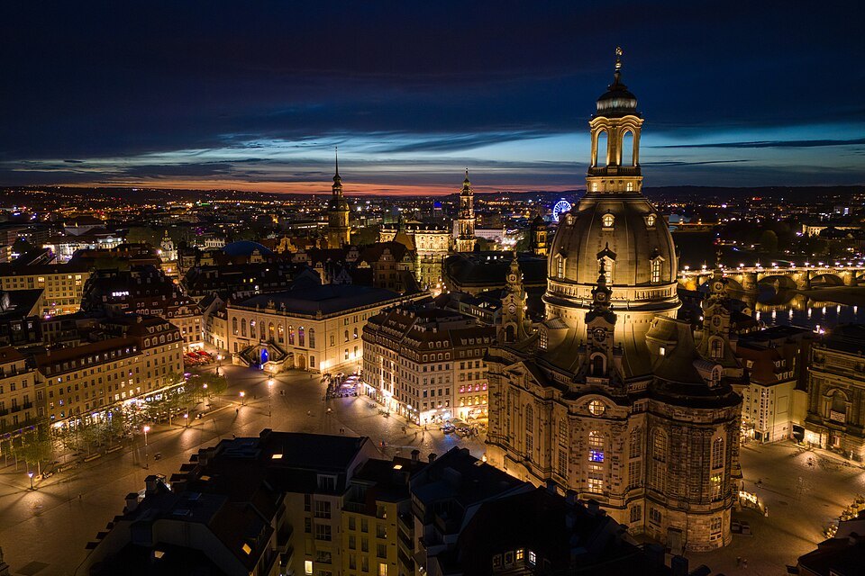 The lit Frauenkirche and Neumarkt from above at night
