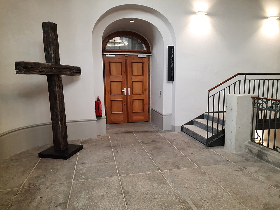 A wooden cross by the tower stair door