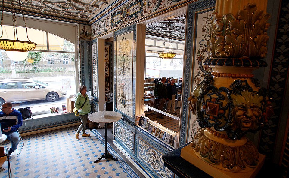 Window seats beside a majolica vase