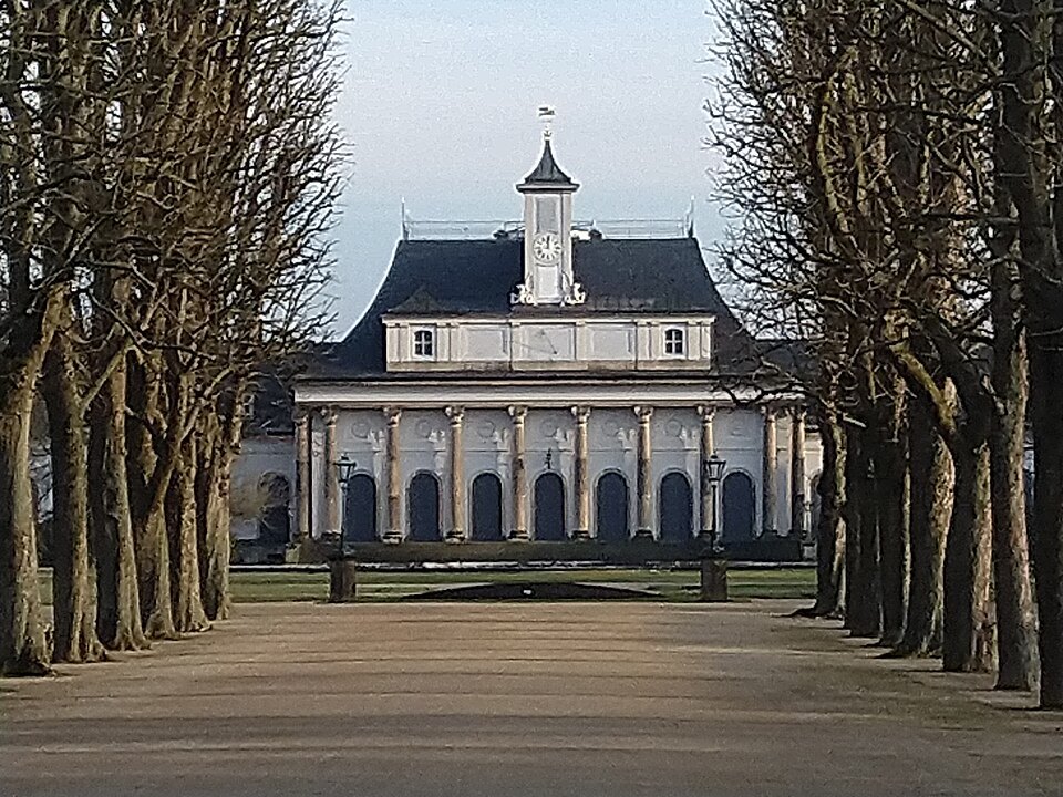 The Neues Palais portal beyond a tree avenue