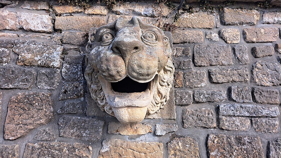 A stone lion's head set in a bastion wall