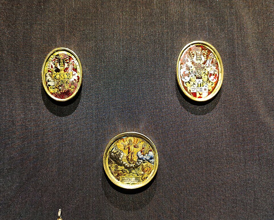 Enameled gold medallions on dark velvet